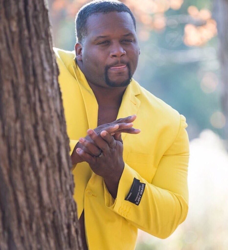 Anthony spice Adams Rubbing Hands in a yellow jacket behind a tree meme template