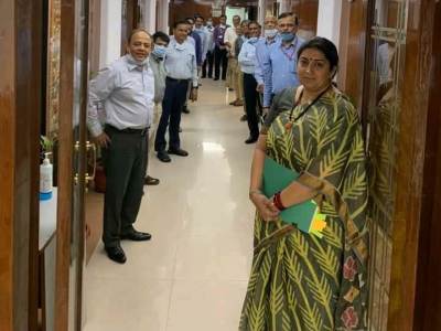 Smriti Irani standing with officers at the office door